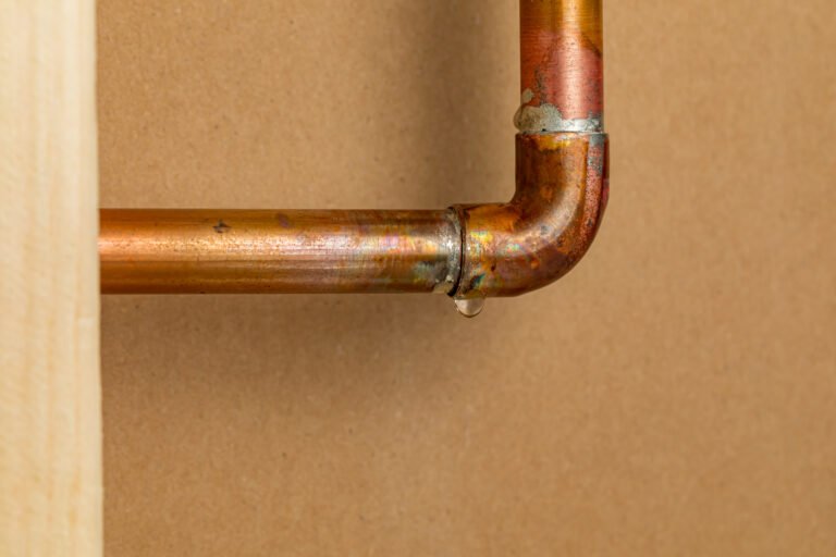 Copper plumbing pipe leaking water inside wall. Home repair, maintenance and remodeling concept.